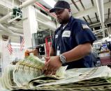 FILE PHOTO: U.S. Bureau of Engraving and Printing employee Williams flips through a stack of newly printed bills at the Bureau of Engraving and Printing in Washington