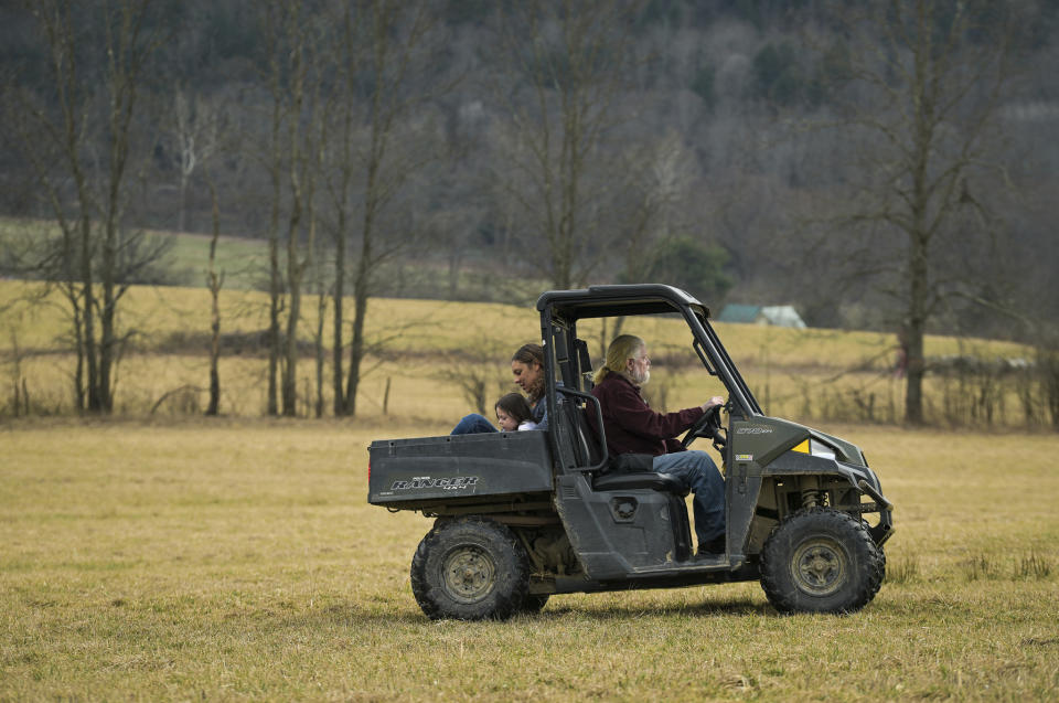 Harold Koster, right, drives his four-wheel vehicle around his 125-acre property with his daughter and granddaughter, Laurel and Lennon Linkroum, at the Koster's farm, Wednesday, March 13, 2024, in Whitney Point, N.Y. The Kosters were asked by Texas-based Southern Tier Energy Solutions to lease their land to extract natural gas by injecting carbon dioxide into the ground, which they rejected and are opposed to. (AP Photo/Heather Ainsworth)