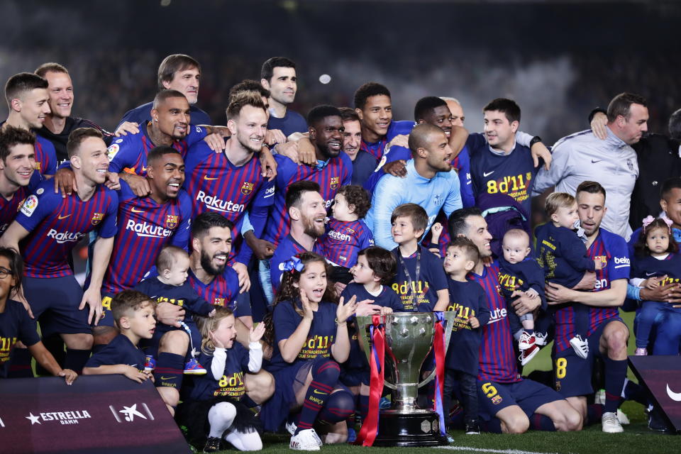 FC Barcelona players, with their children, pose with their trophy after winning the Spanish League title, at the end of the Spanish La Liga soccer match between FC Barcelona and Levante at the Camp Nou stadium in Barcelona, Spain, Saturday, April 27, 2019. Barcelona clinched the Spanish La Liga title, with three matches to spare, after it defeated Levante 1-0. (AP Photo/Manu Fernandez)