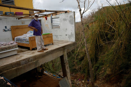 Roberto Morales Santos, 70, looks out after posing for a portrait in his home, damaged by Hurricane Maria, in the municipality of Barranquitas outside San Juan, Puerto Rico October 11, 2017. REUTERS/Shannon Stapleton