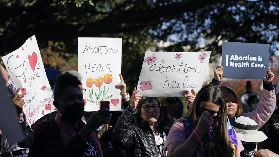 People carry pro-abortion signs. One reads Abortion Heals.