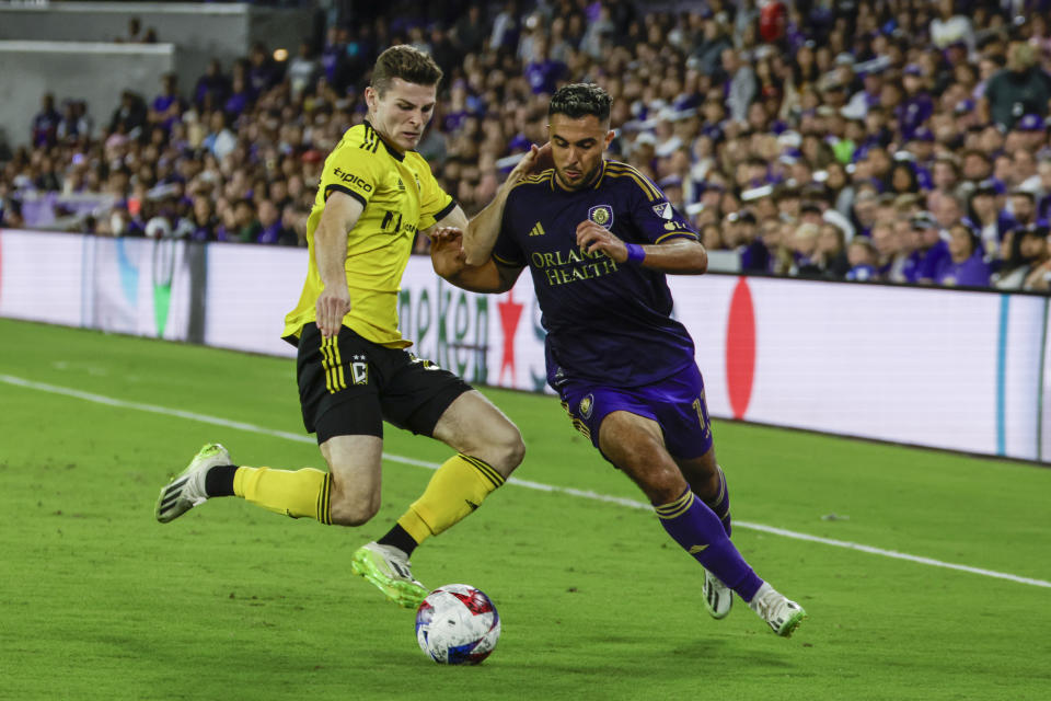 Columbus Crew midfielder Sean Zawadzki, left, and Orlando City midfielder Martín Ojeda, right, go for ball during over time of an MLS soccer playoff match, Saturday, Nov. 25, 2023, in Orlando, Fla. (AP Photo/Kevin Kolczynski)