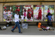 A man chats on the phone while walking past vendors selling various items on the streets of Harare, Tuesday, Sept. 22, 2020. As Zimbabwe's coronavirus infections decline, strict lockdowns designed to curb the disease are being replaced by a return to relatively normal life. The threat has eased so much that many people see no need to be cautious, which has invited complacency. (AP Photo/Tsvangirayi Mukwazhi)