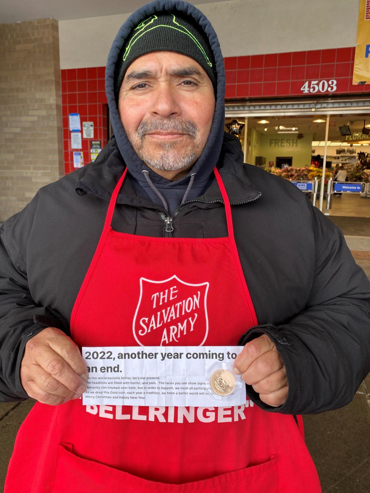 Salvation Army bell ringer Luis Salazar poses with the gold Krugerrand coin that was dropped in his Fort Collins kettle before Christmas. This marks the second year in a row that Salazar's kettle received Fort Collins' Christmas Krugerrand.