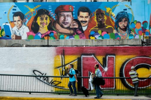 Peatones caminan grente a un graffiti con imágenes del expresidente venezolano Hugo Chávez y del actual mandatario Nicolás Maduro, el 4 de noviembre de 2015 en Petare (AFP | FEDERICO PARRA)