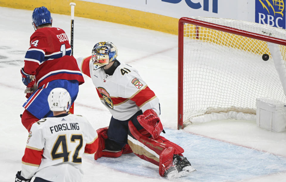 Montreal Canadiens' Nick Suzuki (14) scores against Florida Panthers goaltender Anthony Stolarz (41) as Panthers' Gustav Forsling (42) looks on during the second period of an NHL hockey game in Montreal, Tuesday, April 2, 2024. (Graham Hughes/The Canadian Press via AP)