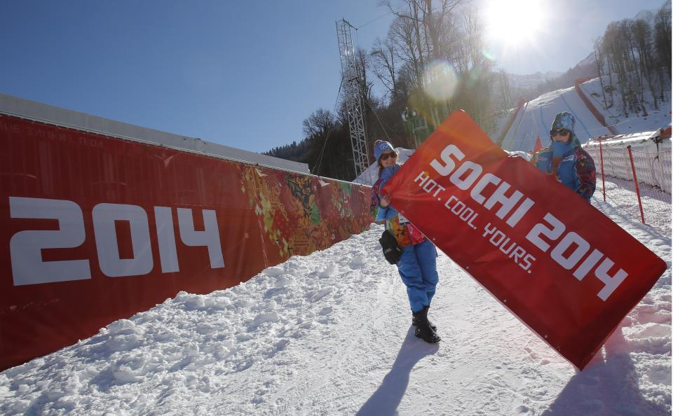 Volunteers put the finishing touches to the look of the finish area of the alpine skiing at the Sochi 2014 Winter Olympics, Wednesday, Feb. 5, 2014, in Krasnaya Polyana, Russia. (AP Photo/Christophe Ena)