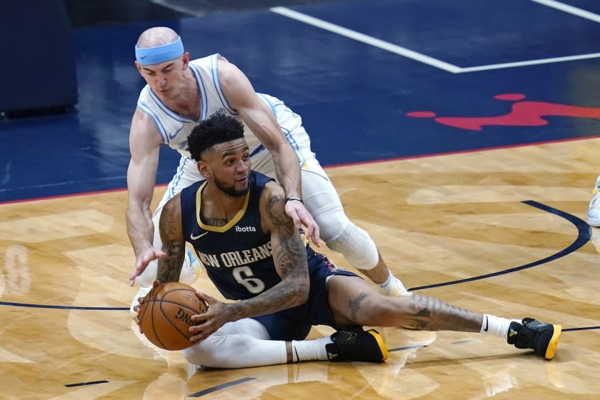 New Orleans Pelicans guard Nickeil Alexander-Walker (6) looks to pass the ball as Los Angeles Lakers guard Alex Caruso defends during the first half of an NBA basketball game in New Orleans, Tuesday, March 23, 2021. (AP Photo/Gerald Herbert)