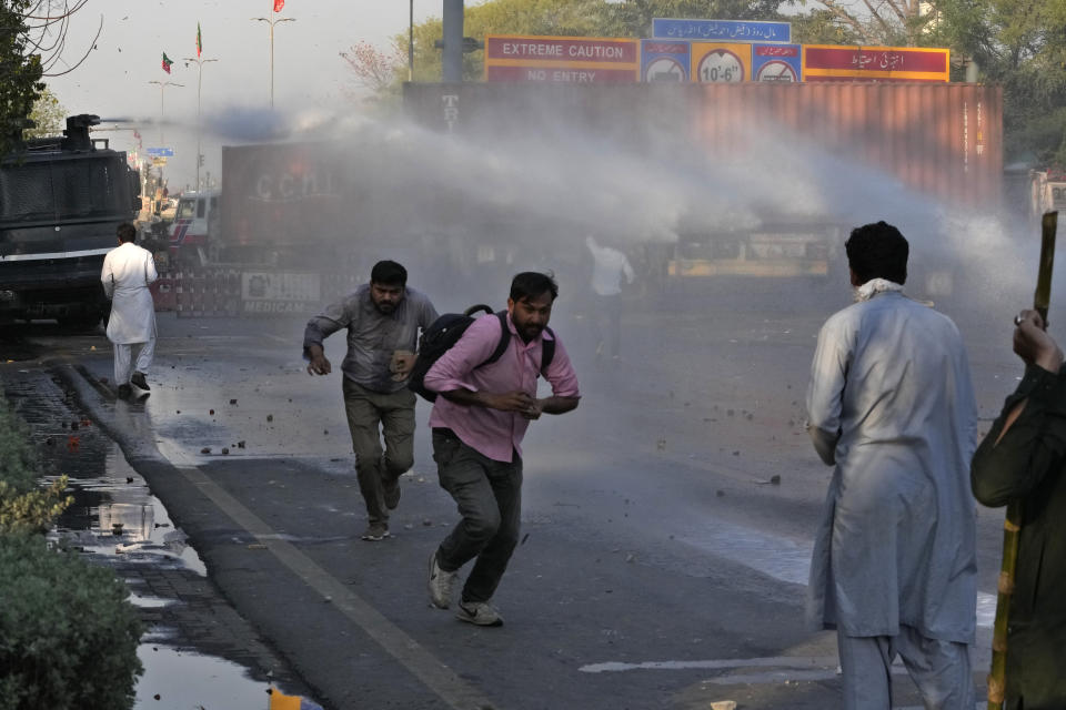 Police officers use water cannon to disperse the supporters of Pakistan's former Prime Minister Imran Khan during clashes, in Lahore, Pakistan, Wednesday, March 8, 2023. Pakistani police used water cannons and fired tear gas to disperse supporters of the country's former Prime Minister Khan Wednesday in the eastern city of Lahore. Two dozen Khan supporters were arrested for defying a government ban on holding rallies, police said. (AP Photo/K.M. Chaudary)