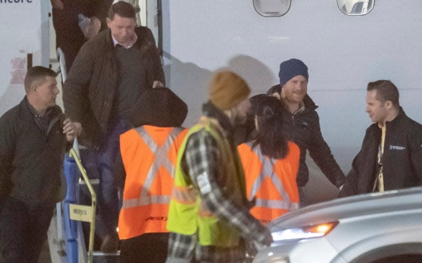 Prince Harry surrounded by security and airport officials in Canada - Paul Grover