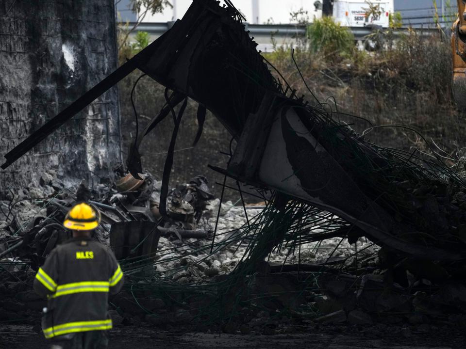 A firefighter views the aftermath of a section of Interstate 95 that collapsed.