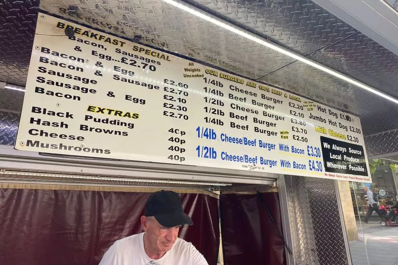 Bill Flynn beneath the huge menu at Bill's Burgers