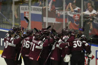 Latvia players celebrate after a penalty shootout at the end of the the preliminary round match between Slovakia and Latvia at the Ice Hockey World Championships in Ostrava, Czech Republic, Sunday, May 19, 2024. (AP Photo/Darko Vojinovic)