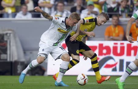 Borussia Dortmund's Marco Reus challenges Borussia Moenchengladbach's Marvin Schulz (L) during their Bundesliga first division soccer match in Gelsenkirchen, Germany August 15, 2015. REUTERS/Ina Fassbender.