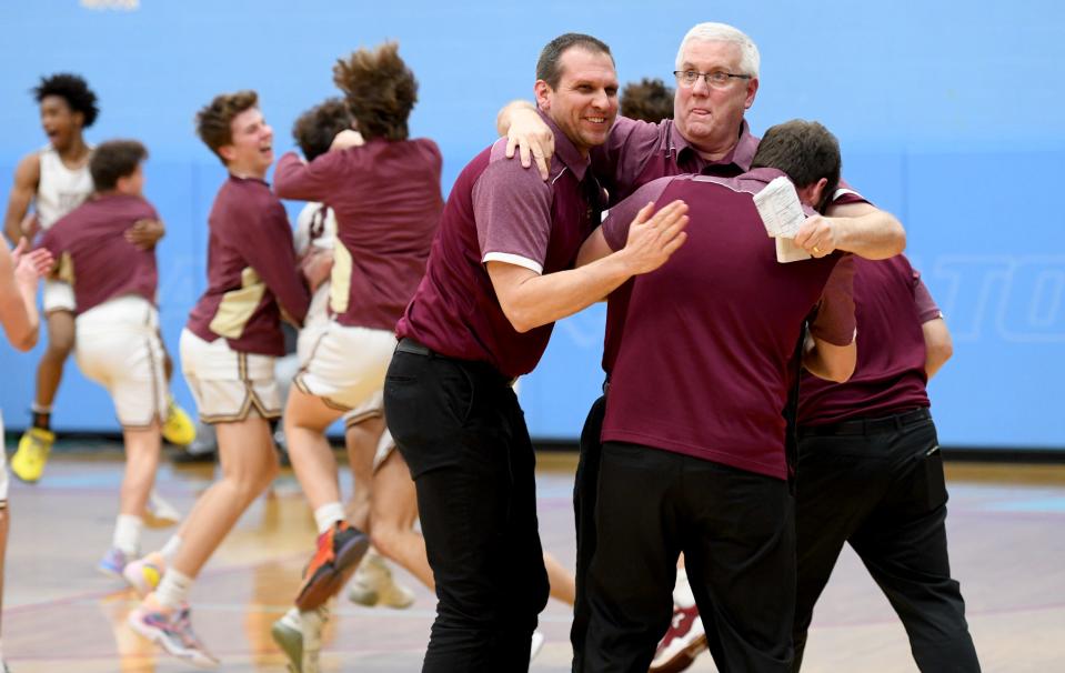 Stow coaches, including head coach David Close, center, celebrate after the Bulldogs beat Jackson in the Division I district final Saturday, March 4, 2023, at Alliance High School.