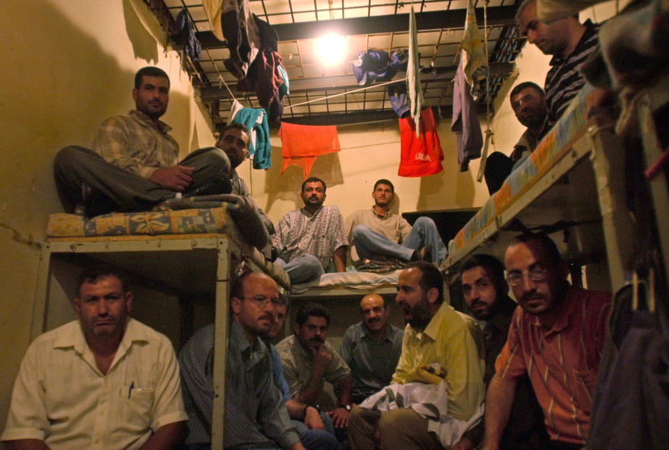 FILE - In this Aug. 3, 2005 file photo, inmates of the notorious Khiam Prison sit in their cell where they displayed their belongings during a sit-in at the prison in Khiam, southern Lebanon. Lebanese Judicial officials said Tuesday, Feb. 4, 2020, that Amer Fakhoury, a Lebanese-American, has been charged with murder and torture of Lebanese citizens while he was working as a warden at the prison, which was run by an Israel-backed Lebanese militia. (AP Photo/Mohammad Zaatari, File)