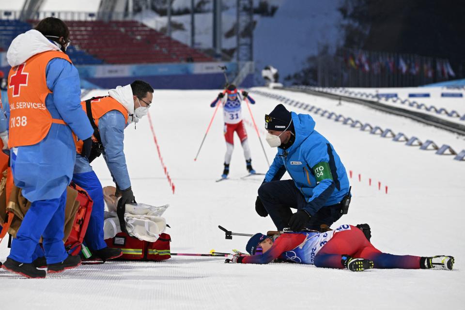 Norway's Ingrid Landmark Tandrevold (R) receives medical attention after the Biathlon Women's 7.5km Sprint event on February 11, 2022 at the Zhangjiakou National Biathlon Centre during the Beijing 2022 Winter Olympic Games. (Photo by Jewel SAMAD / AFP) (Photo by JEWEL SAMAD/AFP via Getty Images)