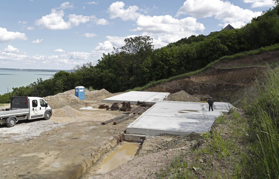 Workers at the construction site at Lake Balaton on the peninsula of Tihany, Hungary - a UNESCO world heritage site - on May 18, 2021. Lake Balaton is the largest lake in Central Europe and one of Hungary's most cherished natural treasures. But some worry that the lake's fragile ecosystem and the idyllic atmosphere of the quaint villages dotted along its banks are in danger because of speculative developments. (AP Photo/Laszlo Balogh)