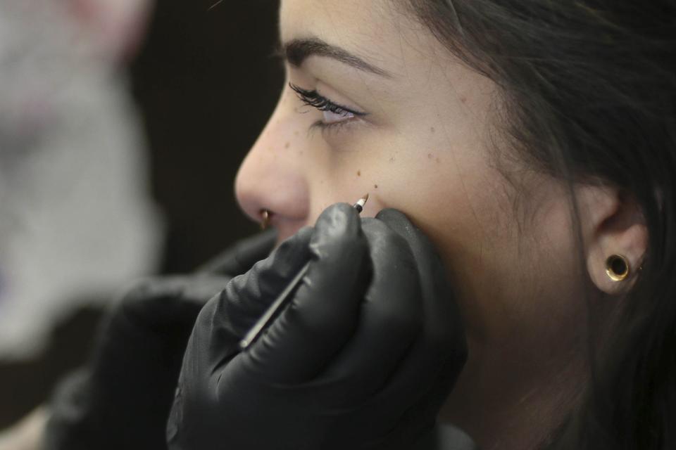 TORONTO, ON - FEBRUARY 6  - Gabrielle Rainbow, a  tattoo artist from Montreal, marks the spots where she will tattoo freckles on client Sarah Strange, 20, at Chronic Ink, February 6, 2017. A trend story about people who are doing this        (Andrew Francis Wallace/Toronto Star via Getty Images)