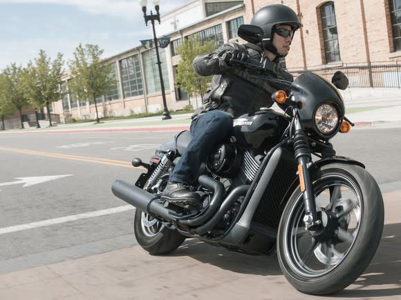 A person riding a Harley-Davidson Street 750 motorcycle on a city street.