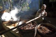 FILE - A man moves a cauldron used for brewing a psychedelic tea locals know as the Holy Daime in Ceu do Mapia, Amazonas state, Brazil on June 22, 2016. Ayahuasca brew is sacred to Ceu do Mapia villagers, who use it in rituals that blend together Indian beliefs with Roman Catholicism. (AP Photo/Eraldo Peres, File)