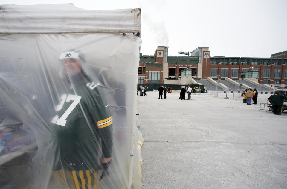 A Green Bay Packers fan looks through a tent as fans tailgate before an NFL wild-card playoff football game between the Green Bay Packers and the San Francisco 49ers, Sunday, Jan. 5, 2014, in Green Bay, Wis. (AP Photo/Jeffrey Phelps)