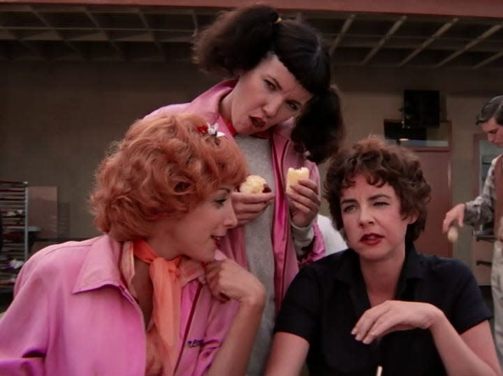 the pink ladies sitting at a picnic table outside school