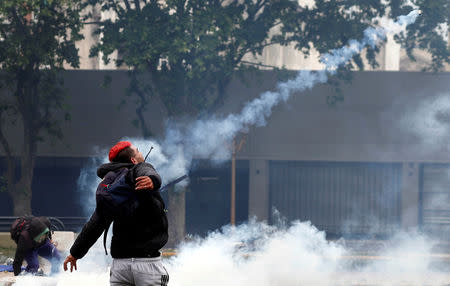 A protester throws back a tear gas canister at the police during clashes outside the Congress, where the budget bill is being debated, in Buenos Aires, Argentina October 24, 2018. REUTERS/Martin Acosta