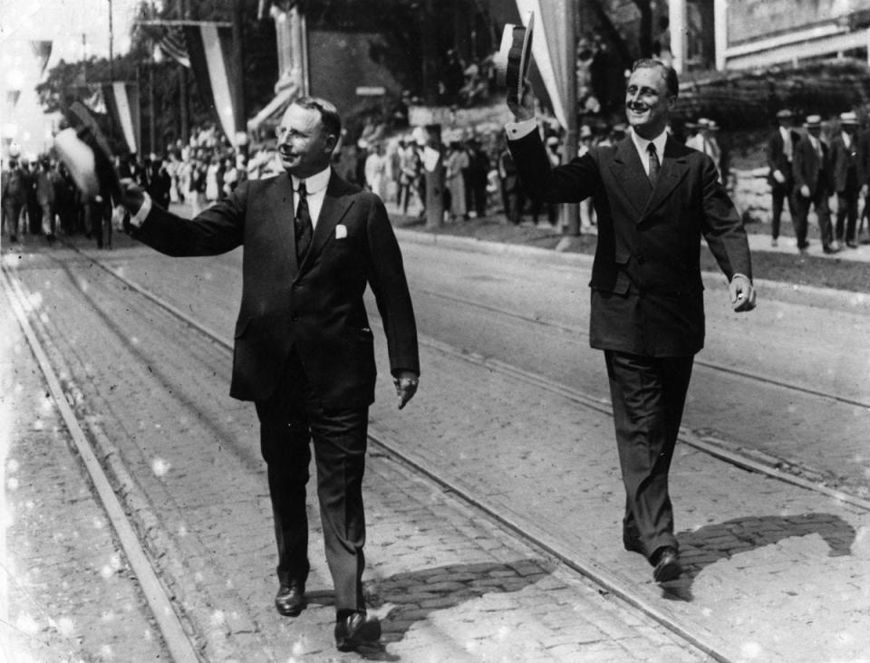 James M. Cox, Democratic nominee for president, left, and his running mate, Franklin Delano Roosevelt, right, march in a parade while campaigning in 1920.