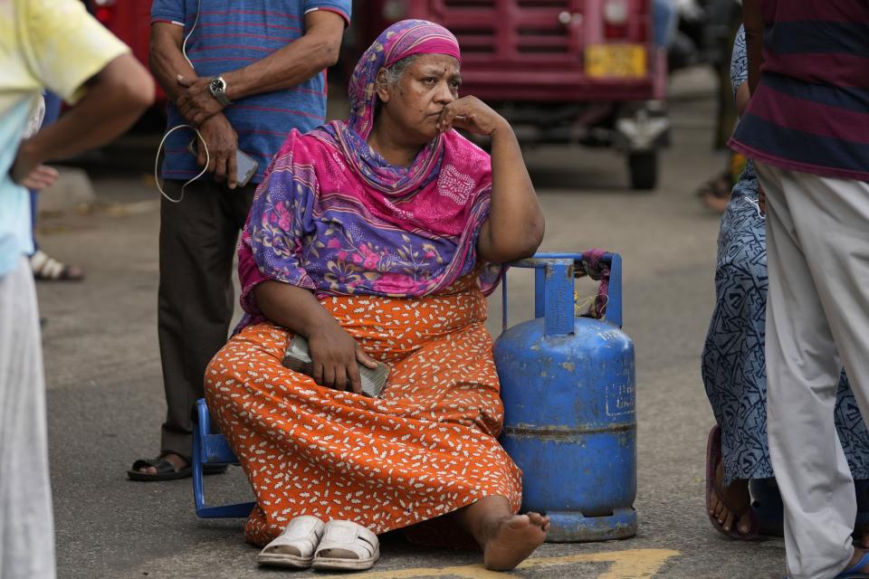 An elderly woman sits outside a police station in a protest demanding cooking gas in Colombo, Sri Lanka, Saturday, May 14, 2022. Sri Lanka's economic crisis, the worst in its history, has completely recast the lives of the country's once galloping middle class. For many families that never had to think twice about fuel or food, the effects have been instant and painful, derailing years of progress toward lifestyles aspired to across South Asia. (AP Photo/Eranga Jayawardena, file)