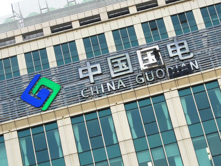 FILE PHOTO: A worker fixes the company logo of China Guodian Corp at a building in Beijing, China January 24, 2013. Picture taken January 24, 2013. REUTERS/Stringer/File Photo