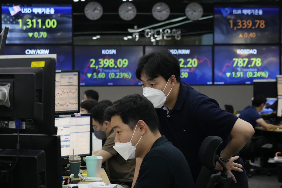 Currency traders watch monitors at the foreign exchange dealing room of the KEB Hana Bank headquarters in Seoul, South Korea, Tuesday, July 26, 2022. Asian stock markets were mostly higher Tuesday as investors braced for another sharp interest rate hike by the Federal Reserve to cool inflation. (AP Photo/Ahn Young-joon)