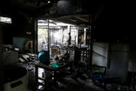 <p>A forensic expert inspects a burned building at the Pitakkiat Wittaya School in Chiang Rai province, Thailand, on May 23, 2016. At least 17 girls reportedly died in the fire. (Athit Perawongmetha/Reuters) </p>