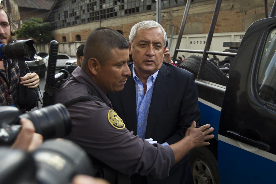 FILE - In this June 13, 2016 file photo, Guatemalan former President Otto Perez Molina is escorted by police into a court hearing in Guatemala City. Molina was imprisoned after the U.N.-sponsored anti-graft commission known as the CICIG, working hand in hand with local prosecutors, brought corruption cases against him. (AP Photo/Moises Castillo, File)