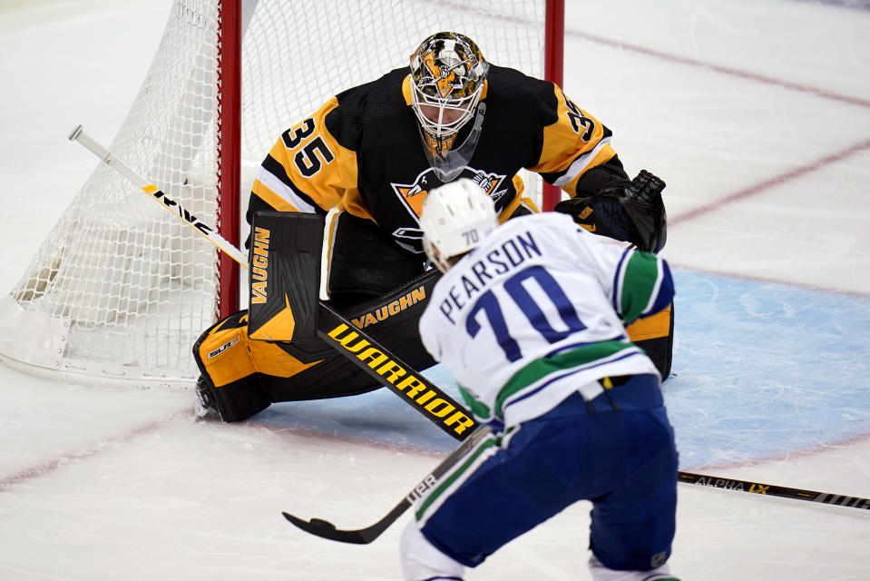 Pittsburgh Penguins goaltender Tristan Jarry (35) blocks a shot by Vancouver Canucks' Tanner Pearson (70) during the first period of an NHL hockey game in Pittsburgh, Wednesday, Nov. 24, 2021. (AP Photo/Gene J. Puskar)