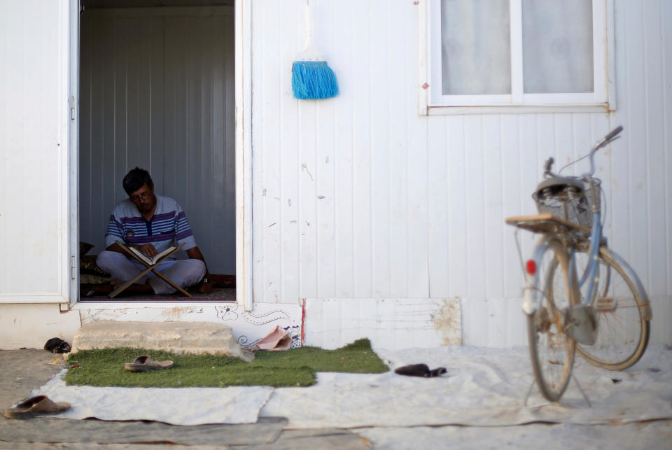 A Syrian refugee man reads the Koran inside his home at the Al-Zaatari camp.