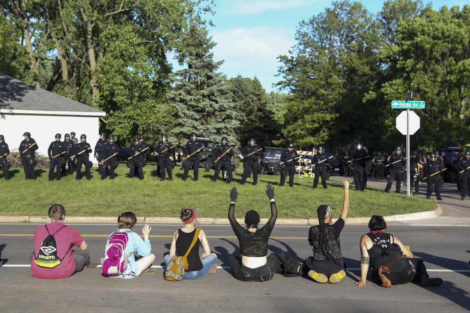 Demonstrators sit before a police line outside the home of Derek Chauvin, the since-fired Minneapolis officer who pinned down George Floyd with a knee on his neck, in the suburb of Oakdale on May 28. | Jenn Ackerman—The New York Times/Redux