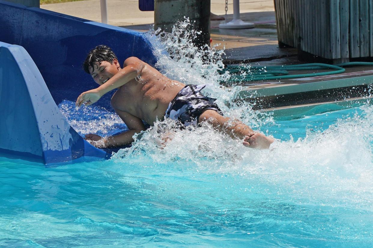 Jordan Gauna of Adrian enjoys going down the slide in June 2022 at Bohn Pool in Adrian.