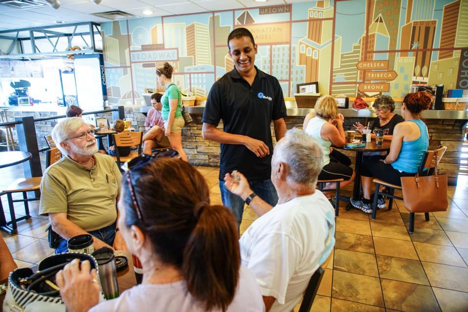 Rishen Patel, who owns Manhattan Bagel in Middletown, visits with a group of customers who come into his shop daily to enjoy the food and atmosphere.