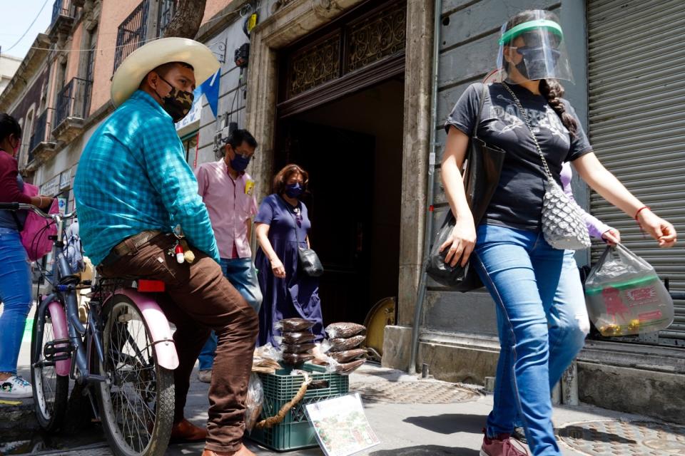 People walk by one of the branches of the landmark Paris pharmacy in downtown Mexico City.