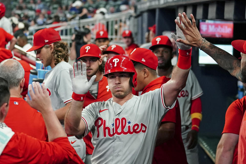 Philadelphia Phillies' J.T. Realmuto celebrates in the dugout after hitting a solo home run in the fourth inning of a baseball game against the Atlanta Braves Monday, Sept. 18, 2023. (AP Photo/John Bazemore)