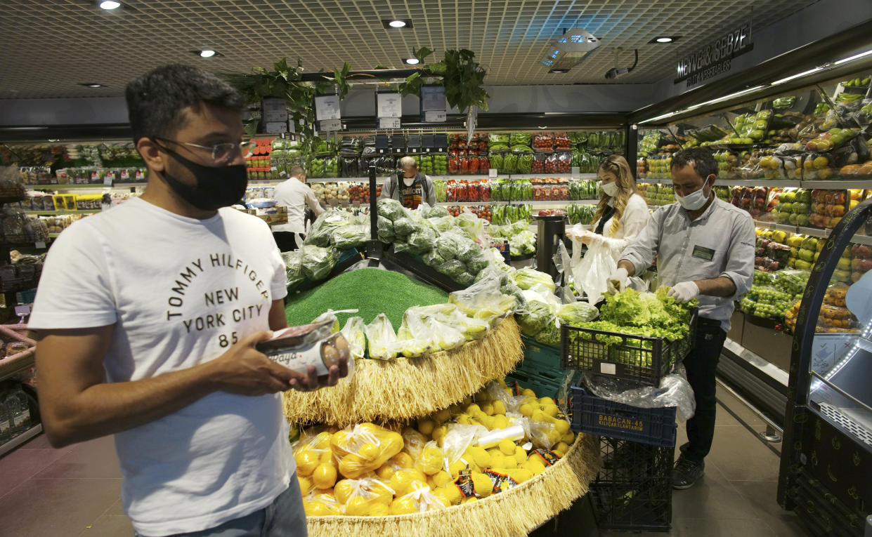 People wearing face masks for protection against the coronavirus, shop for food at a market hours before a four-day new curfew declared by the government in an attempt to control the spread of coronavirus, in Ankara, Turkey on May 22. (Burhan Ozbilici/AP Photo)