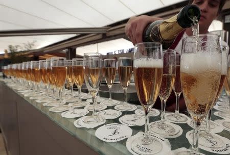 A man pours champagne into a glass at a private beach bar along La Croisette during the 66th Cannes Film Festival in Cannes May 17, 2013. REUTERS/Eric Gaillard