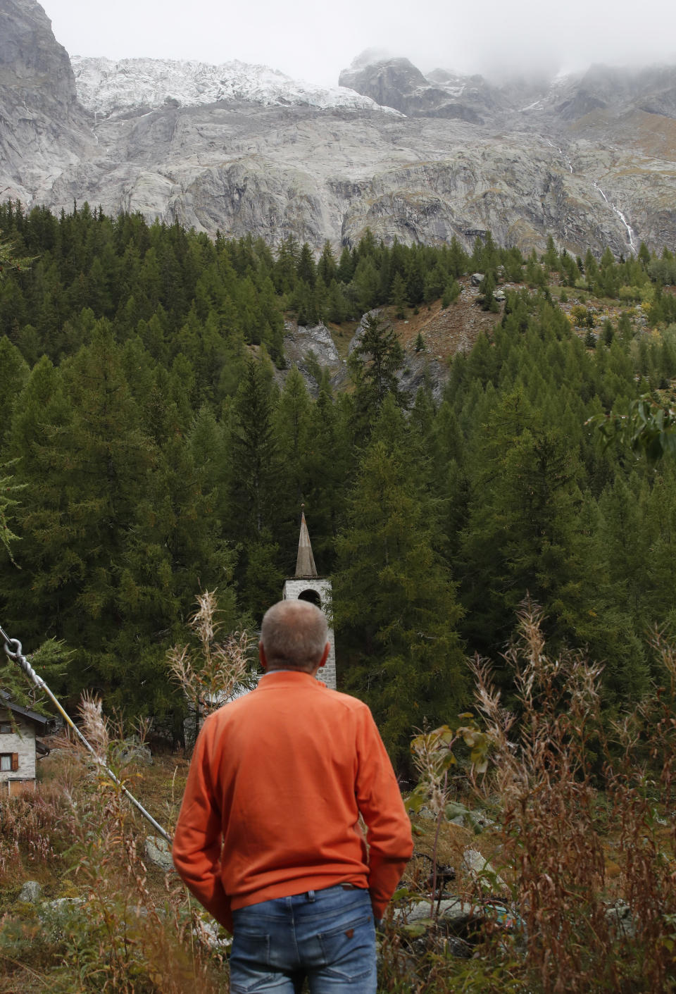 Marco Belfrond looks the Plancipieux glacier near Courmayeur, northern Italy, Thursday, Sept. 26, 2019. Italian officials sounded an alarm Wednesday over climate change due to the threat that a fast-moving melting glacier is posing to the picturesque Val Ferret valley near the Alpine town of Courmayeur. The Planpincieux glacier, which spreads 1,327 square kilometers (512 square miles) across the Grande Jorasses peak of the Mont Blanc massif, has been moving up to 50 centimeters (nearly 20 inches) a day (AP Photo/Antonio Calanni)