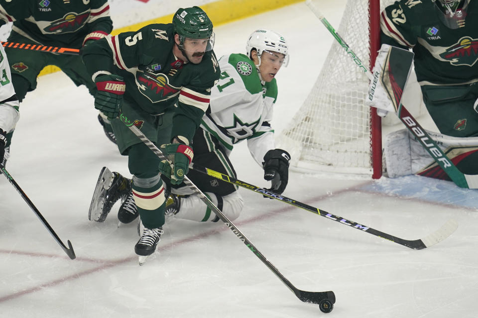 Minnesota Wild defenseman Jake Middleton, left, and Dallas Stars left wing Jason Robertson vie for the puck during the first period of an NHL hockey game Friday, Feb. 17, 2023, in St. Paul, Minn. (AP Photo/Abbie Parr)