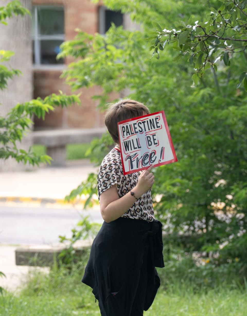 A student holds a sign during Monday's demonstration at McCallum High.
