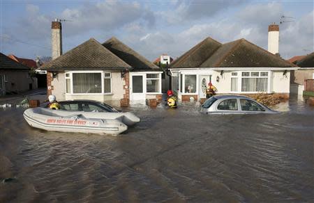 Emergency rescue service workers check houses in a flooded residential street in Rhyl, north Wales December 5, 2013. REUTERS/Phil Noble