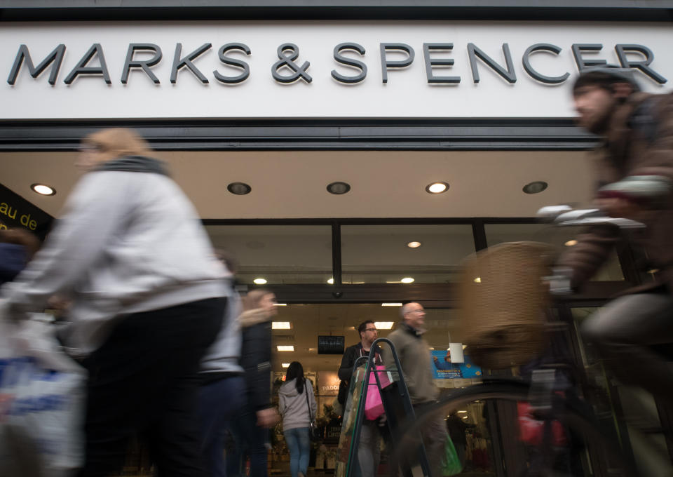 Shoppers pass a branch of Marks and Spencer on the main shopping street. (Photo by Matt Cardy/Getty Images)