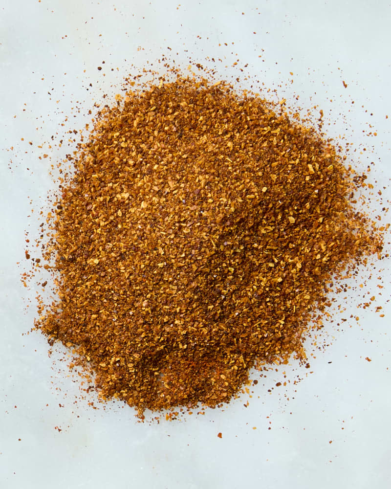 overhead shot of a pile of regular paprika on a white marble background.