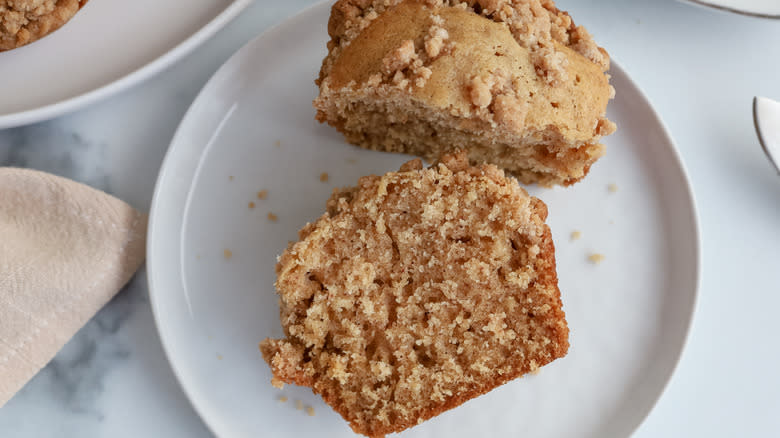 whole and halved snickerdoodle crumb muffin on plate